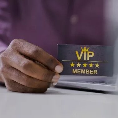 A hand proudly holds a black VIP member card between finger and thumb